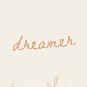 May include: A beige background with the word "dreamer" written in a light brown cursive font. The bottom of the image features a row of stylized brown and white leaves.