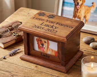 Könnte beinhalten: Eine rechteckige Gedenkbox aus Holz für Haustiere mit dunkelbrauner Oberfläche. Der Deckel ist mit zwei Pfotenabdrücken und dem Text "Love You Forever Lucky 2005-2022" graviert. Die Vorderseite enthält einen Fotorahmen mit einem Golden Retriever.
