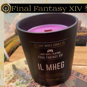 May include: A black candle with a purple wax interior and a wooden wick. The candle is in a black container with the text "Final Fantasy XIV" and "IL MHEG". The candle is from Light While Candle Co.
