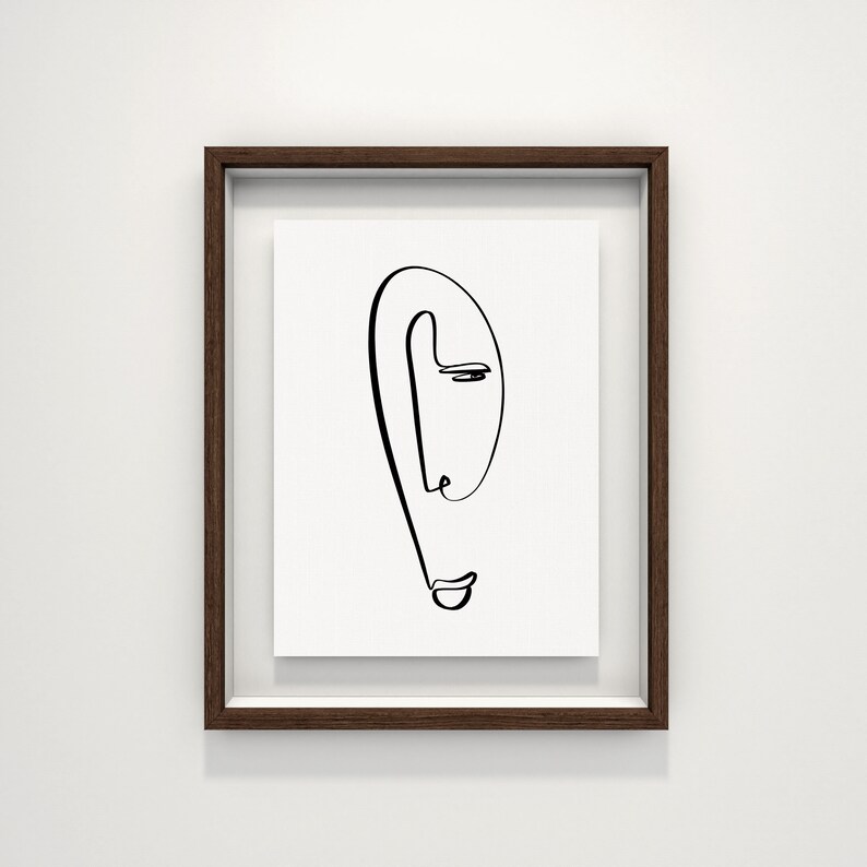 Puede incluir: Un dibujo en blanco y negro de una cara en un marco de madera marr&oacute;n.