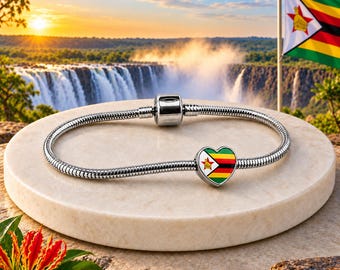 May include: A silver snake chain bracelet featuring a heart-shaped charm decorated with the national flag of Zimbabwe, which includes green, yellow, red, black, and white stripes with a red star and a yellow bird emblem on a white triangle.