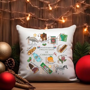 May include: White square pillow with a colorful illustration of the South African Twelve Days of Christmas. The design includes images of a bird, food, and a zebra, with text labels. Festive holiday decor.