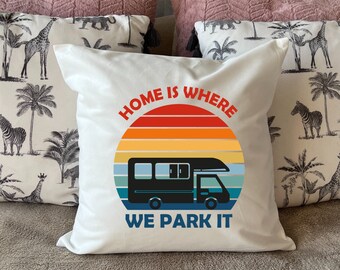 May include: White throw pillow with a black and white camper van graphic and the text "Home is where we park it" in a retro sunset design.