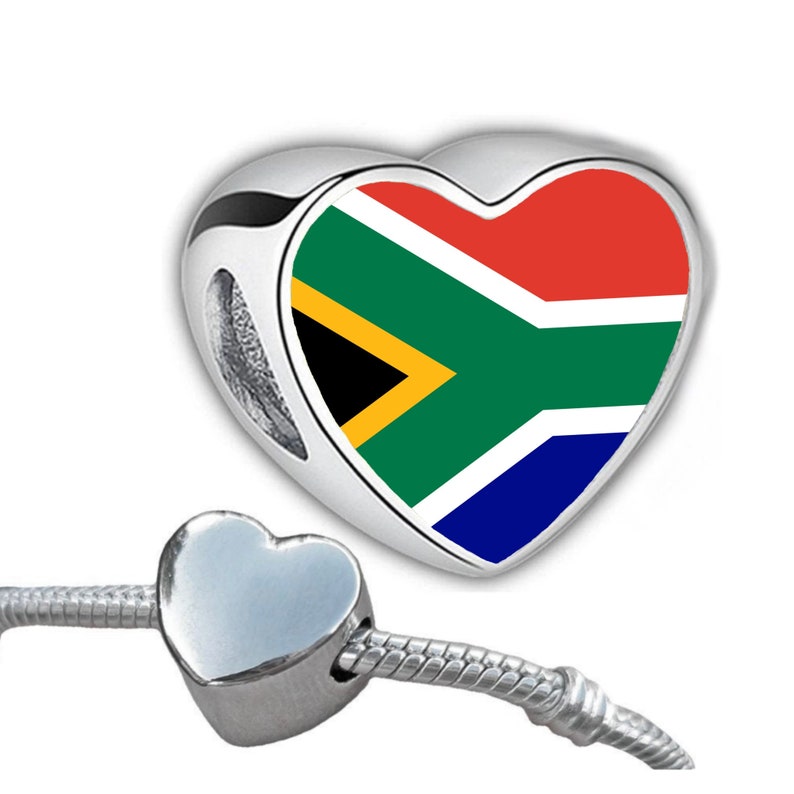 May include: A silver charm in the shape of a heart, featuring the South African flag in red, white, blue, yellow, and green. The charm is attached to a silver bracelet. The charm is a heart shape.