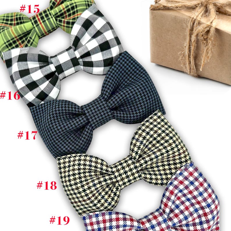 May include: A collection of bow ties in various patterns, including green plaid, black and white gingham, navy blue houndstooth, and black and cream check. Each bow tie is neatly arranged, showcasing the different designs and textures. A brown gift box tied with twine is in the background.