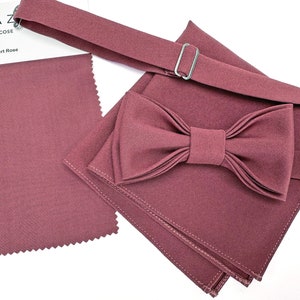 Può includere: Un papillon bordeaux con un fazzoletto da taschino abbinato e un cinturino abbinato. Il tessuto è una viscosa morbida e testurizzata.