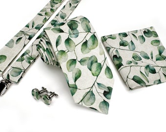 May include: A set of men's accessories featuring a green and white patterned tie, suspenders, pocket square, and cufflinks. The pattern is a watercolor design of eucalyptus leaves.