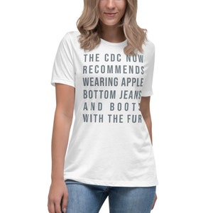 May include: White t-shirt with the text "THE CDC NOW RECOMMENDS WEARING APPLE BOTTOM JEANS AND BOOTS WITH THE FUR"