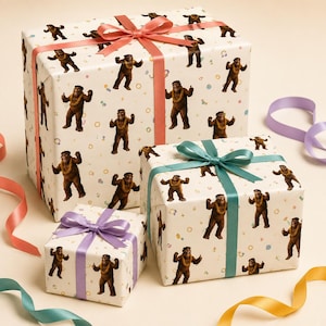 May include: Three rectangular gift boxes wrapped in white paper featuring a repeating pattern of brown, furry creatures wearing yellow leis. The largest box has a coral ribbon, the medium box has a teal ribbon, and the smallest has a lavender ribbon.