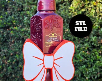 May include: A burgundy hand soap bottle with a decorative bow. The bottle has a pump and a label that reads "Afternoon Apple Picking." The bow is white with red trim. The image also includes a black circle with the text "STL FILE."