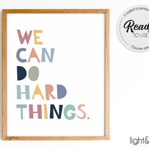 May include: A framed print with the text "WE CAN DO HARD THINGS." in colorful letters. The letters are in different colors, including blue, green, yellow, and pink.
