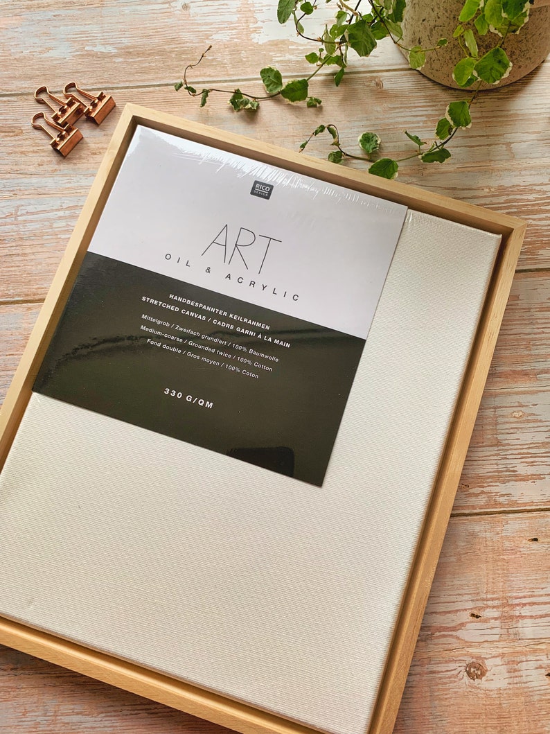 May include: A wooden frame with a white canvas stretched inside. The canvas is labeled "Art Oil & Acrylic" and has the text "Handbespannter Keilrahmen Stretched Canvas/Cadre Garni a la Main Mittelgrob/Zweifach grundiert/100% Baumwolle Medium-coarse / Grounded twice/100% Cotton Fond double/Gres moyen/100% Caton 330 G/QM".