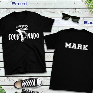 May include: Black t-shirt with a white graphic of a tornado with the text "category four NADO". The back of the shirt has the name "MARK" in white letters.
