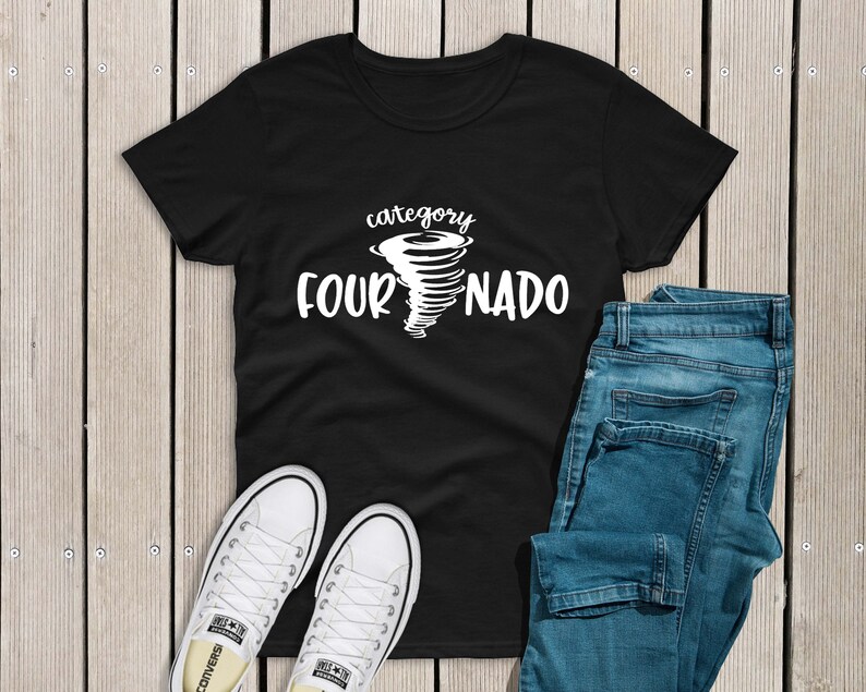 May include: Black t-shirt with a white graphic of a tornado and the text "category fournado". The shirt is laid flat on a wooden surface with a pair of white sneakers and blue jeans.