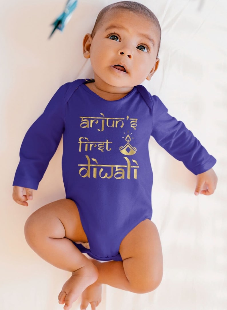 A baby in a blue Diwali bodysuit