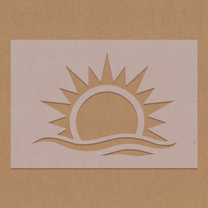 May include: A white stencil of a sun rising over a wavy line, representing the ocean. The stencil is on a brown background.