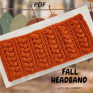 May include: A crochet headband in a bright orange color. The headband has a textured pattern and is made with a chunky yarn. The text "FALL HEADBAND" and "LETS ALL CROCHET" is printed below the headband. The image is labeled "PDF".