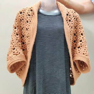 Crochet Pattern Cocoon shrug medium weight lion brand yarn. Easy beginner crochet cocoon cardigan or boho crochet sweater for women in sizes XS to 5XL. Blanket shrug made from rectangle with easy lacy pattern of puff stitch and half double crochet.