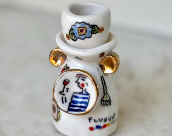 Pieza única de porcelana pintada a mano con detalles en oro de 22 quilates.