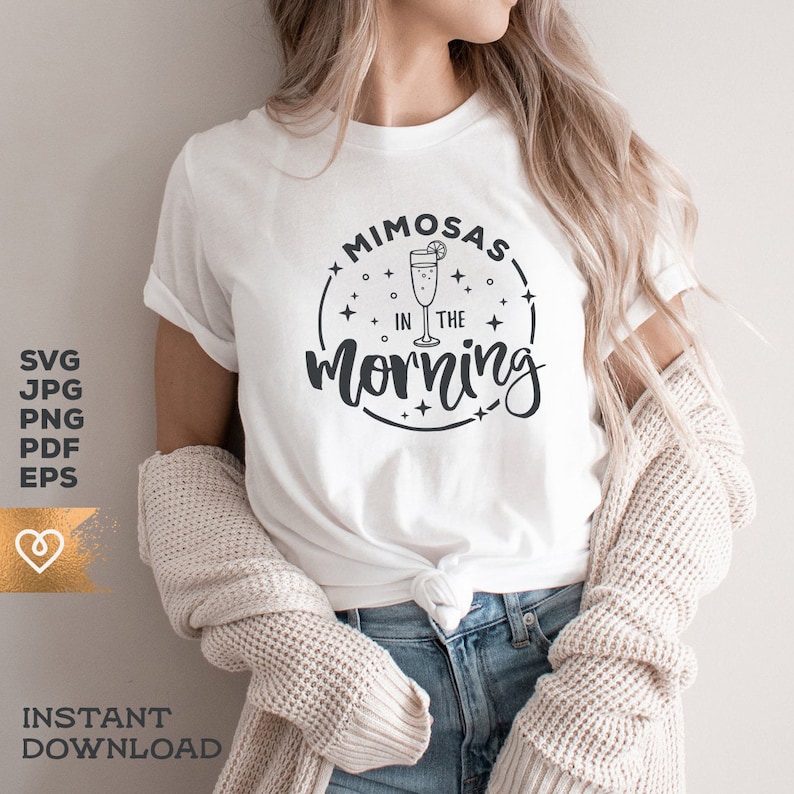 May include: White t-shirt with a black graphic design that says "Mimosas in the morning" with a drawing of a mimosa glass.
