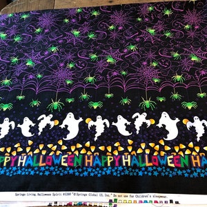 May include: Black fabric with a Halloween print featuring ghosts, spiders, webs, and candy corn. The fabric has the text "Happy Halloween" repeated across the bottom. The fabric is labeled "Springs Living, Halloween Spirit #5380 "Springs Global US, Inc. Do not use for Children's sleepwear."
