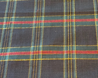 May include: Black fabric with a plaid pattern in red, green, and gold thread.