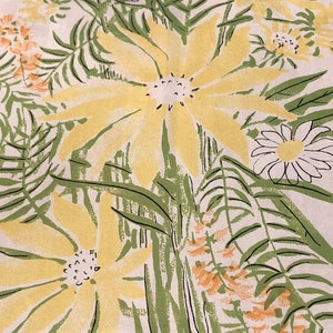 May include: A white fabric with a yellow and green floral pattern. The flowers are stylized and have a vintage look. The background is a light cream color.