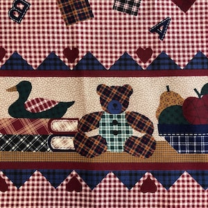 May include: Red and white gingham fabric with a border of blue and red triangles. The fabric features a teddy bear, a duck, and a basket of fruit. The fabric also has letters 'A', 'B', and 'C' scattered throughout.