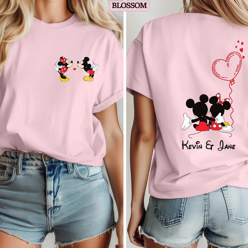 May include: A light pink t-shirt featuring Mickey and Minnie Mouse. The front of the shirt shows the characters kissing, while the back displays them embracing with a heart-shaped balloon and the names "Kevin & Jane". The word "BLOSSOM" is at the top.