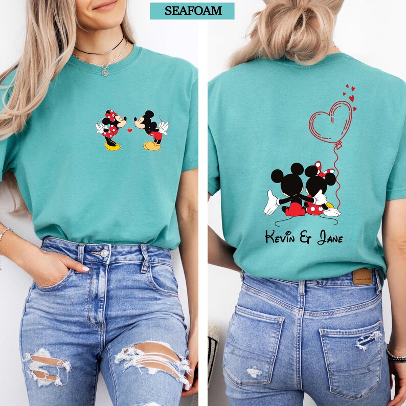 Puede incluir: Camiseta verde mar con un dise&ntilde;o de Mickey y Minnie Mouse. La parte delantera muestra a la pareja bes&aacute;ndose, y la trasera los muestra con un globo de coraz&oacute;n y los nombres "Kevin & Jane".