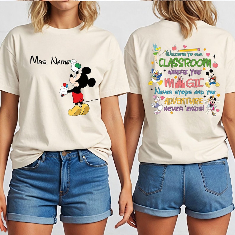 Puede incluir: Camiseta color crema con Mickey Mouse sosteniendo un rotulador rojo y el texto "Mrs. Name". La parte trasera de la camiseta tiene el texto "Welcome to our Classroom" con personajes de Disney y la frase "Never stops and the Adventure Never Ends!"