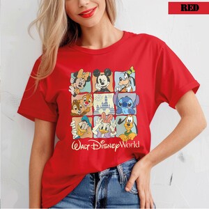 May include: Red t-shirt with a grid design showcasing Disney characters such as Mickey Mouse, Minnie Mouse, Goofy, Donald Duck, Daisy Duck, Chip and Dale, Stitch, and the Cinderella Castle. The words "Walt Disney World" are printed below.