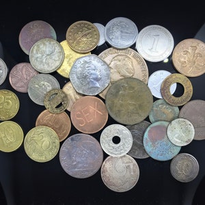 May include: A collection of various coins from around the world, including gold, silver, and copper coins. Some of the coins feature images of people, animals, and buildings.