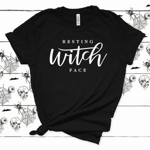 May include: Black t-shirt with white text that reads "Resting Witch Face".