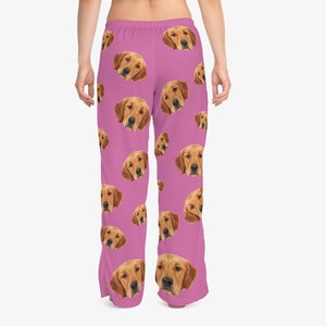 May include: Pink pajama pants with a repeating pattern of a golden retriever's face.