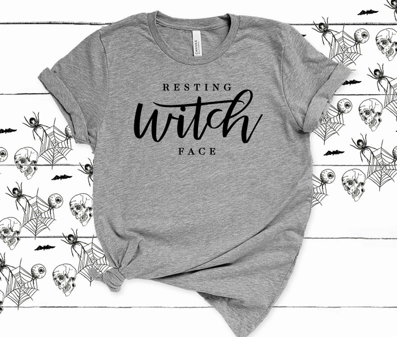 May include: A gray t-shirt with the text "Resting Witch Face" printed in black.
