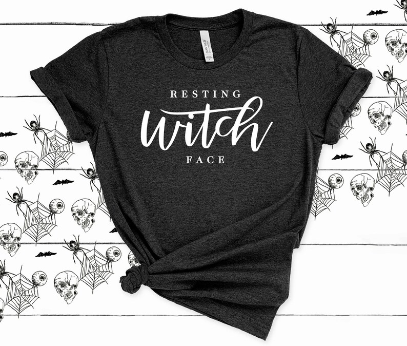 May include: A dark gray t-shirt with the text "Resting Witch Face" in white lettering.