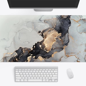 May include: Abstract desk mat with a gray, black, and gold marble design. The mat is made of a durable, non-slip material and is perfect for protecting your desk from scratches and spills.