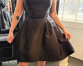 Schwarzes ausgestelltes plus Größe Kleid, das Audrey Hepburn gibt