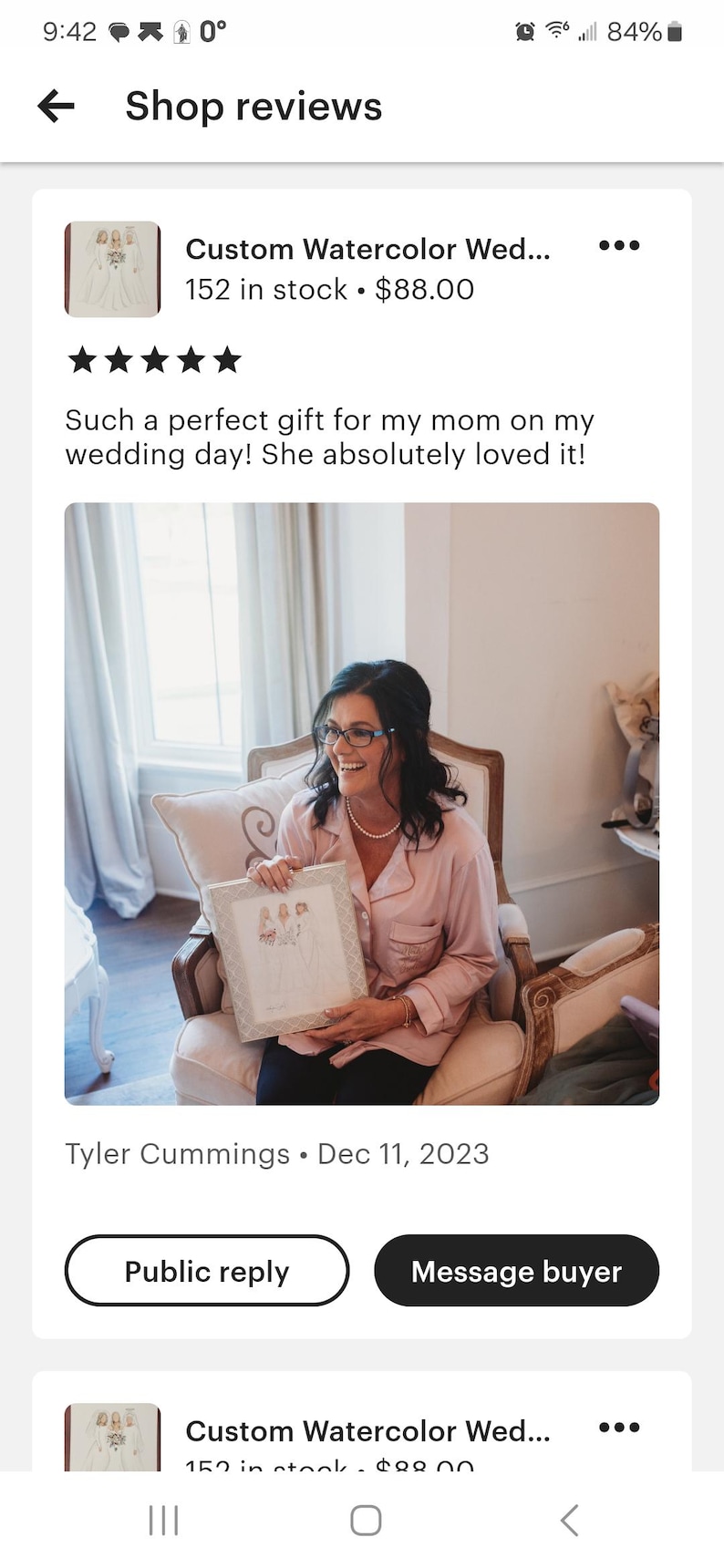 K&ouml;nnte beinhalten: Ein Aquarellbild von drei Personen in Hochzeitskleidung, gerahmt in einem wei&szlig;en Rahmen mit einem dekorativen Rand. Das Bild wird von einer Person in einem rosa Morgenmantel gehalten, die auf einem Stuhl sitzt.