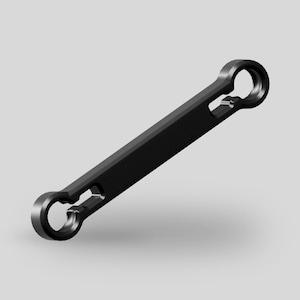 以下が含まれることがあります： 中央に穴が空いた丸い端が2つある、黒い金属製のレンチです。