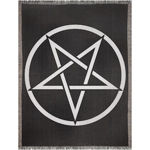 May include: Black throw blanket featuring a large white pentagram symbol within a circle. The blanket has a woven texture and fringed edges. A gothic or occult-themed home decor item.