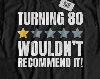 Puede incluir: Camiseta negra con un mensaje de cumpleaños humorístico que dice "Turning 80 Wouldn't Recommend It!" con una calificación de una estrella.