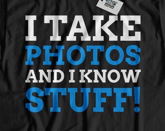 May include: Black t-shirt with the text "I take photos and I know stuff!" in white and blue lettering.