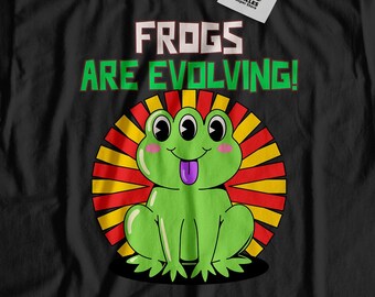 May include: Black t-shirt with a green frog with three eyes and a long tongue. The frog is in front of a red, yellow, and green sunburst. The text "FROGS ARE EVOLVING!" is above the frog.