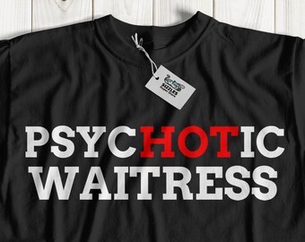 May include: Black t-shirt with the words "PSYCHOTIC WAITRESS" printed in white and red. The shirt is laid flat on a light wood-grain surface. A small tag hangs from the collar.
