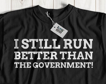 I Still Run Better Than The Government Unisex Funny Broken Leg T-Shirt | Leg Amputee Gift Ideas | Paralyzed Gifts | Wheelchair Shirt