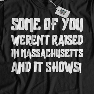 以下が含まれることがあります： 「Some of you weren't raised in Massachusetts and it shows!」という白い文字が書かれた黒いTシャツ
