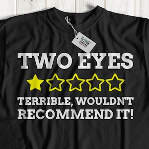 May include: Black t-shirt with white text that reads "TWO EYES TERRIBLE, WOULDN'T RECOMMEND IT!" and a row of five yellow stars.