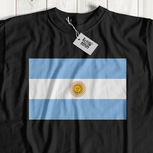 May include: A black t-shirt with the flag of Argentina printed on the front. The flag is light blue and white with a yellow sun in the center.